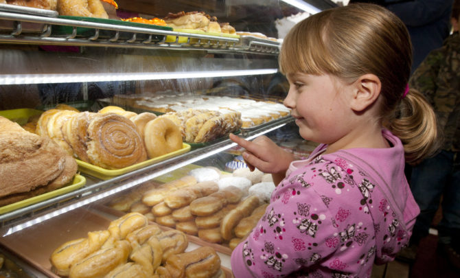 child-looking-at-doughnut-case